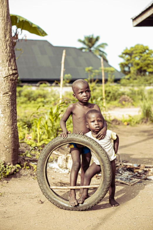 a boy and a girl holding onto a tire