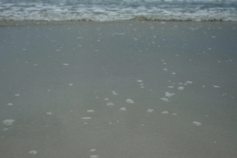 closeup of a beach with waves and sand