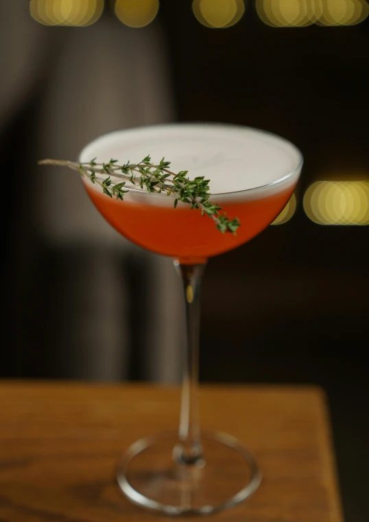 a martini drink with garnish sits on a bar