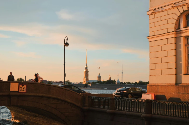 there are cars traveling on a bridge and people in the distance