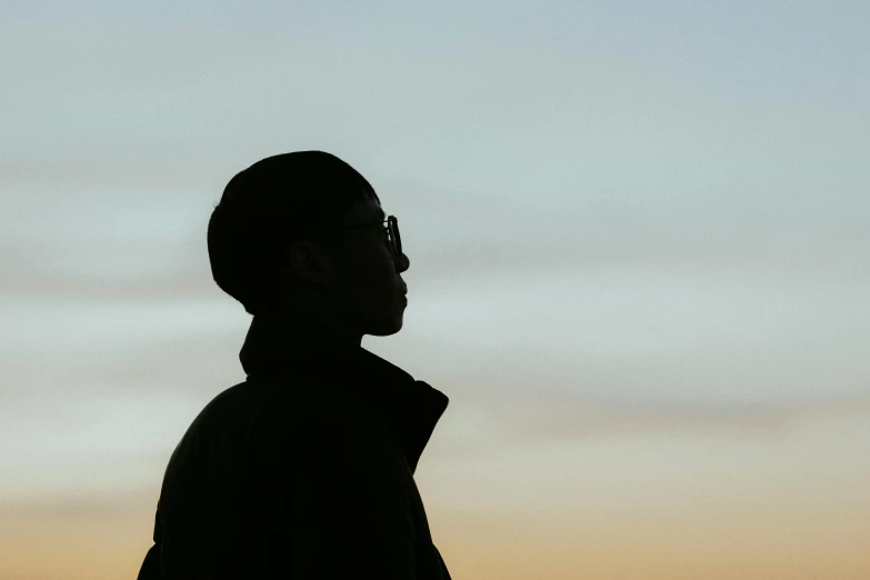 a man in front of a cloudy sky