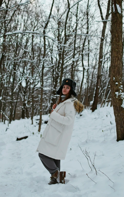 a woman in winter gear is standing on a snowy path