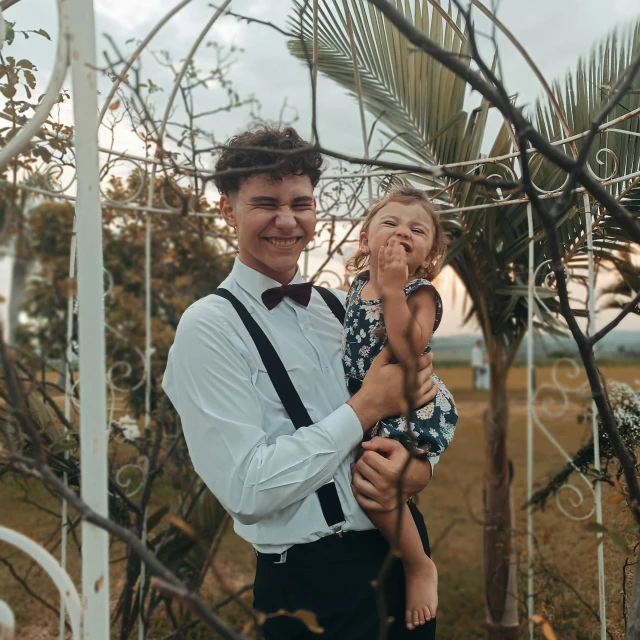 the woman is holding her daughter under a tree