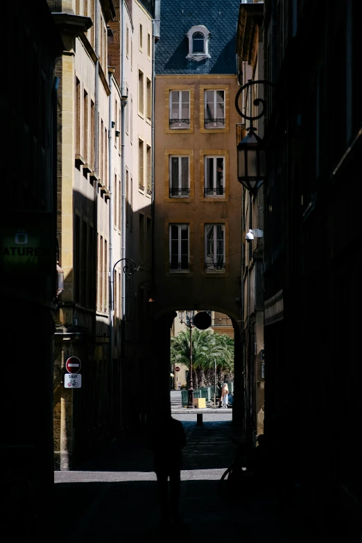 a person is standing on an alley with many buildings in the background