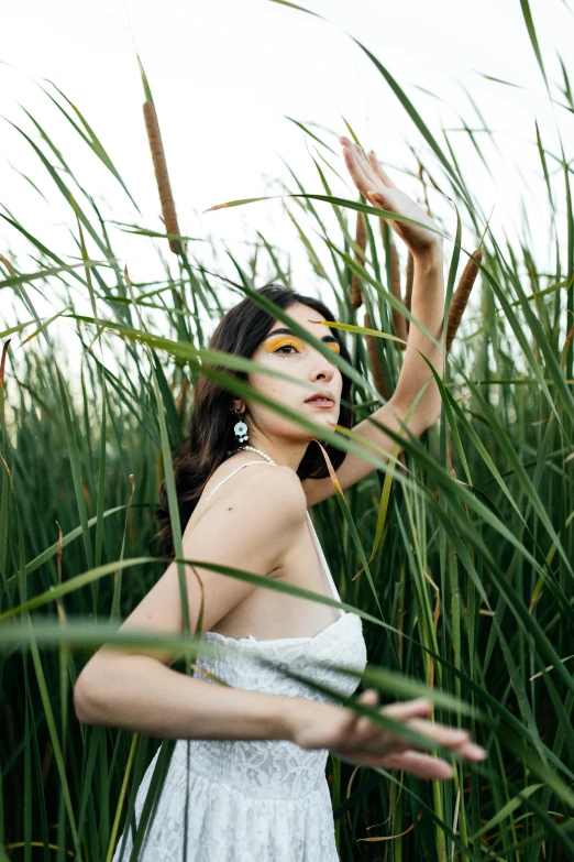 a woman is standing in tall grass by herself