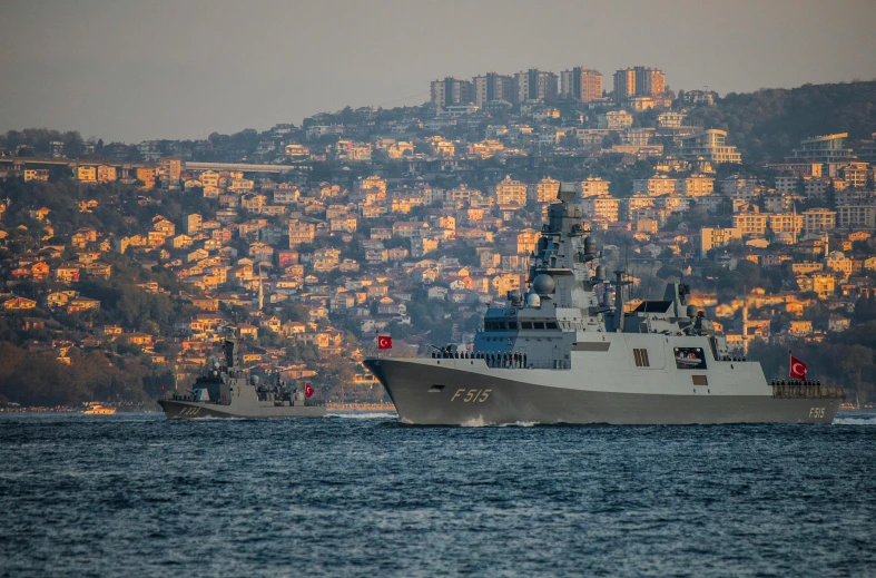 a large boat in front of a small boat on the water