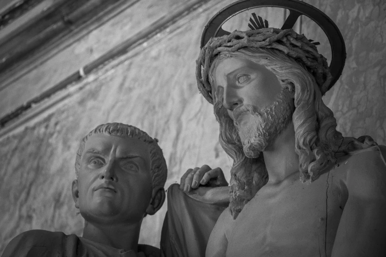 two people standing near each other next to a statue