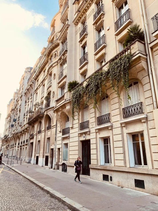 two people walking on the sidewalk near a building