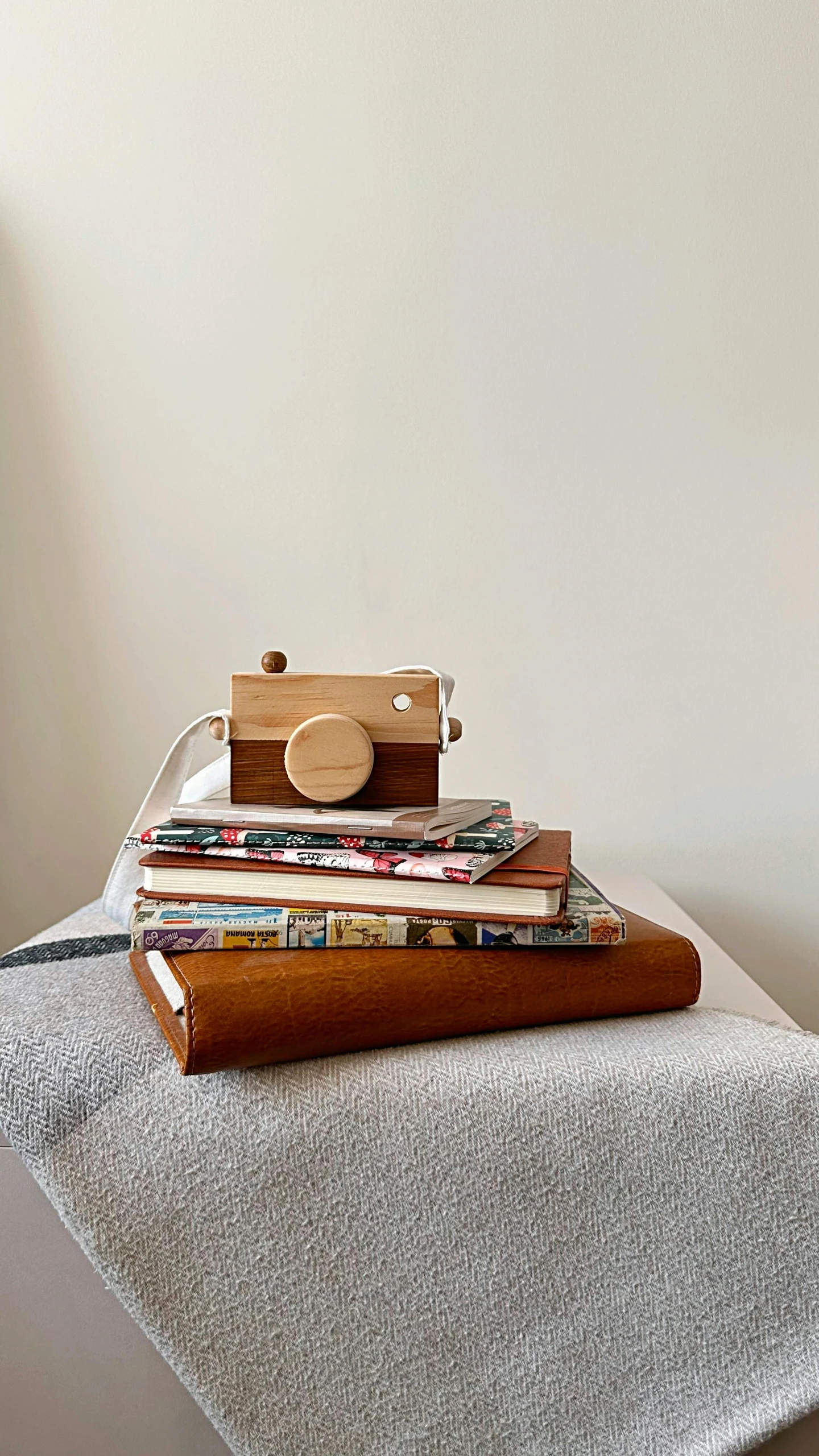 there is a wooden camera on a stack of magazines