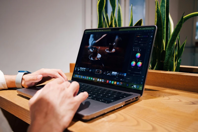 a man using his laptop while sitting on a table