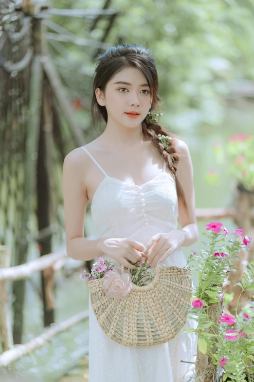 a young woman wearing a white dress holding a woven basket