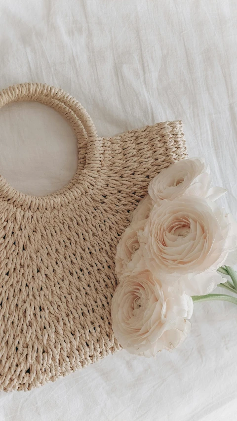 an image of a bag and flower on a bed