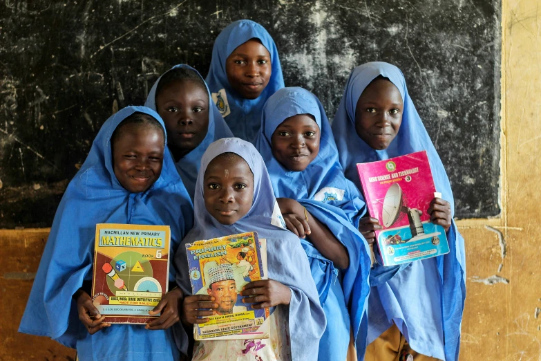 a group of s standing side by side holding books