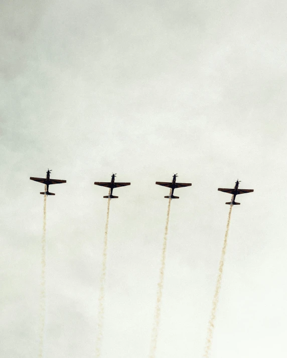 four fighter jets with contrails are in the sky