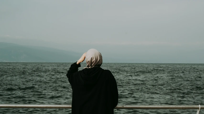 a person standing on a pier looking over a body of water