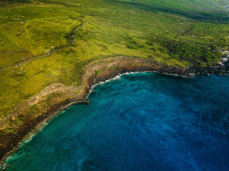 a green field next to the ocean and a beach