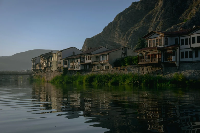 a row of houses near a water front with a rocky shoreline