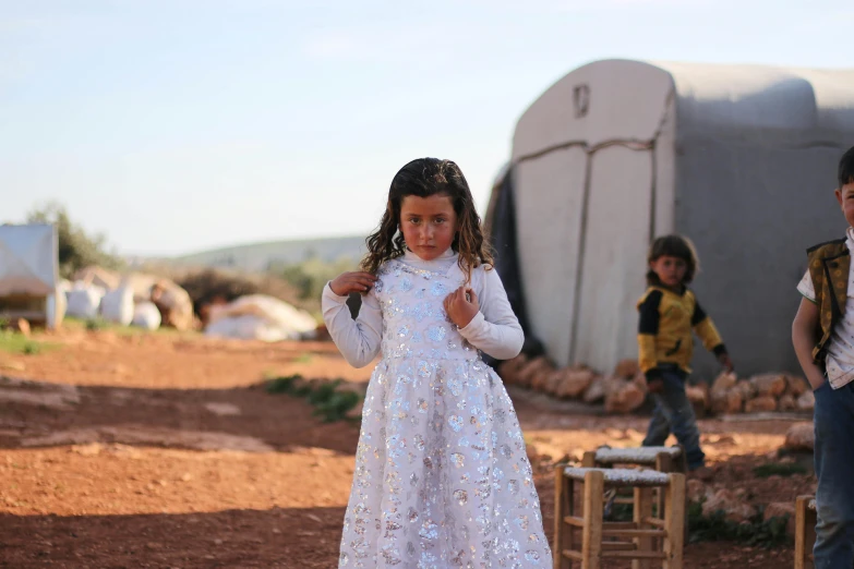 a little girl and boy are playing outside in the dirt