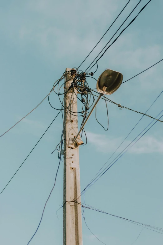 a very tall telephone pole sitting next to a street