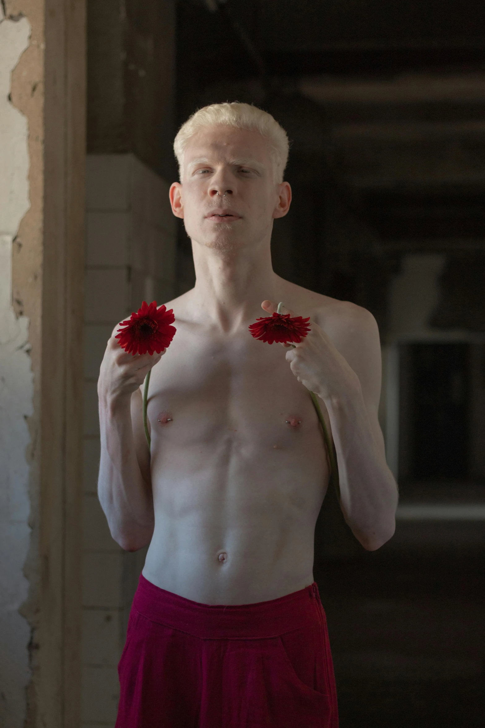 young man with flowers showing off his body