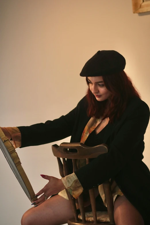 a woman dressed in black is sitting on a chair with a large knife