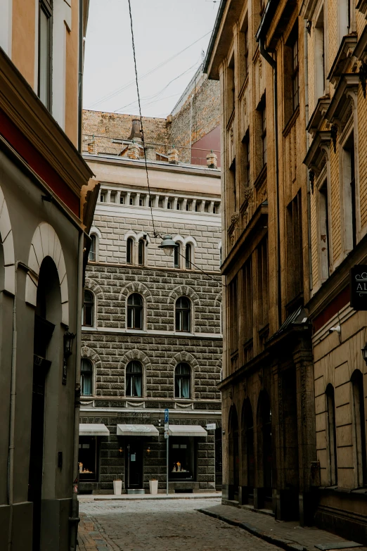 a man is walking down an old street in a large city