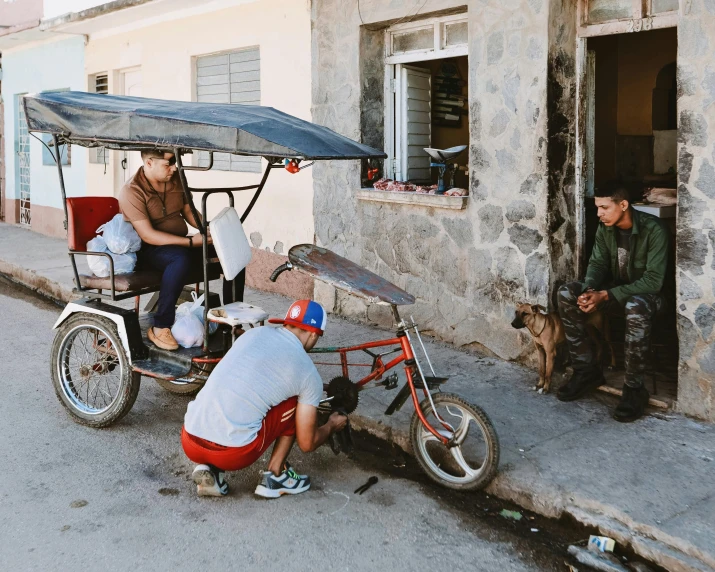 two people on a small motorized bike next to another person