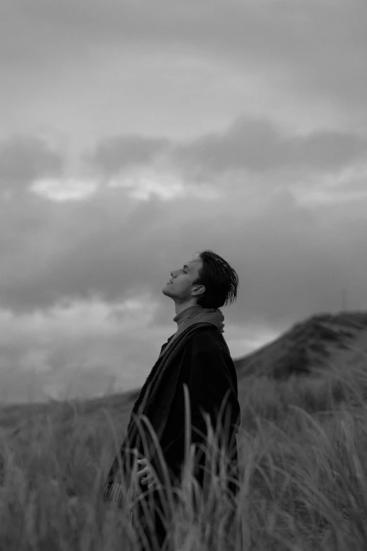 a man standing in tall grass looking up