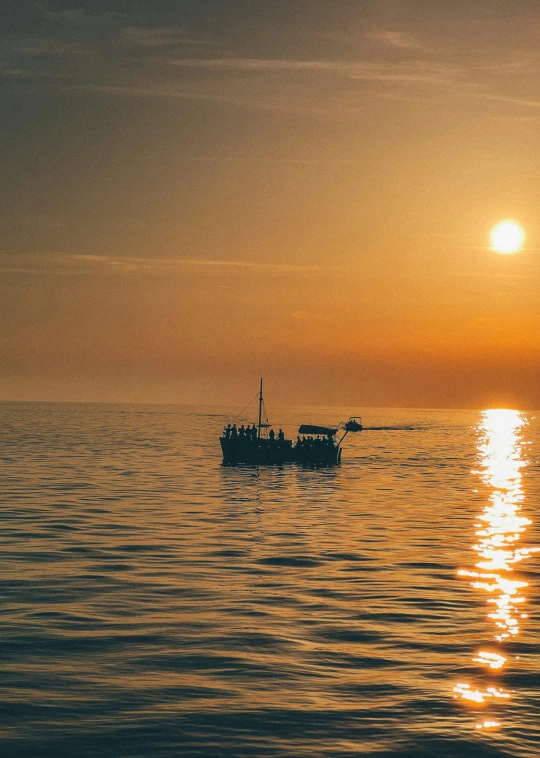 boats sailing on water near the shore during sunset