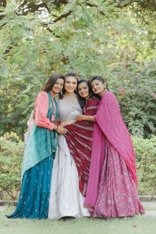 four young women pose for a portrait in indian clothing