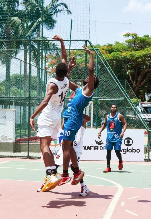 a man jumping up for a basketball during a game