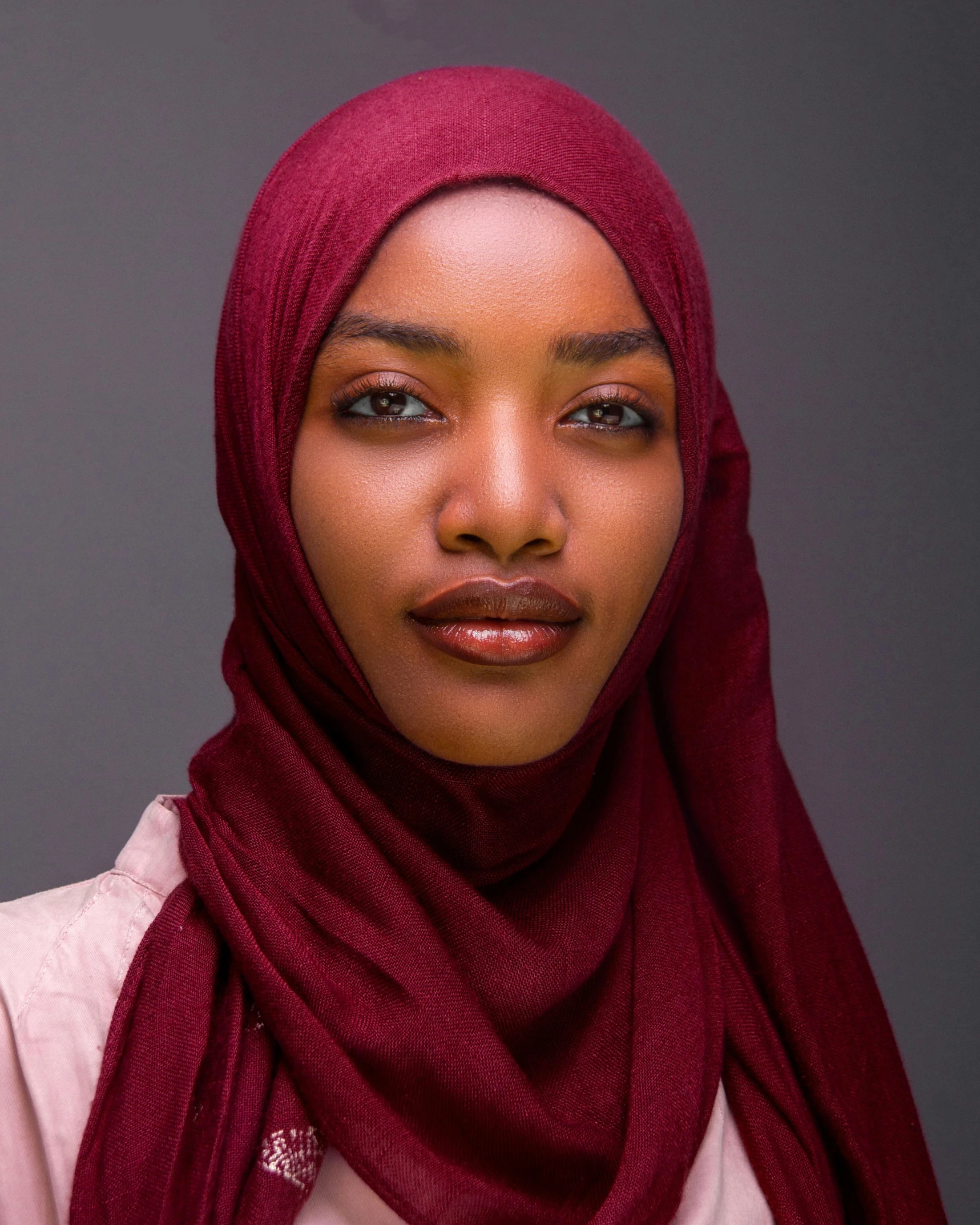 an african american woman wearing a headscarf and a pink top