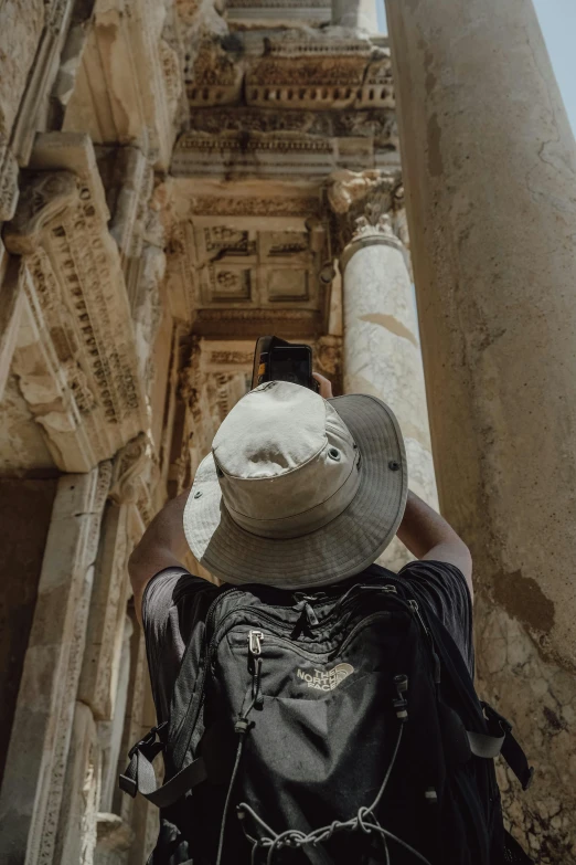 a person taking a po on a cell phone near ruins