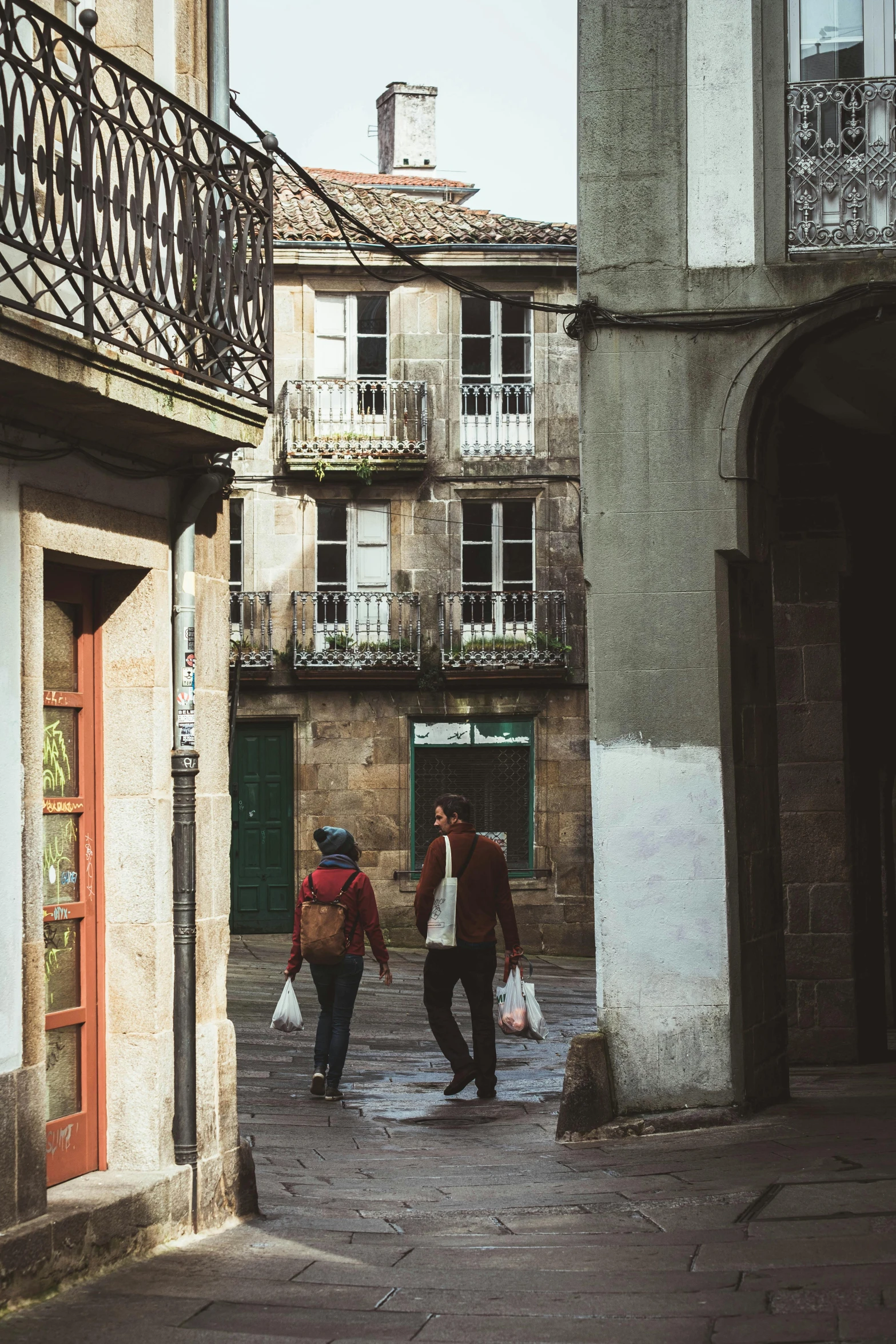 some people with a dog are walking in a cobblestone area