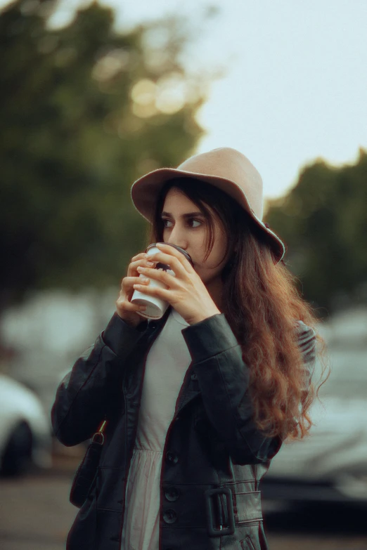 a woman drinking water from a cup in her hand