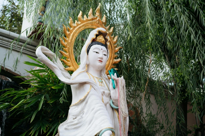 the large white statue is dressed in oriental clothing