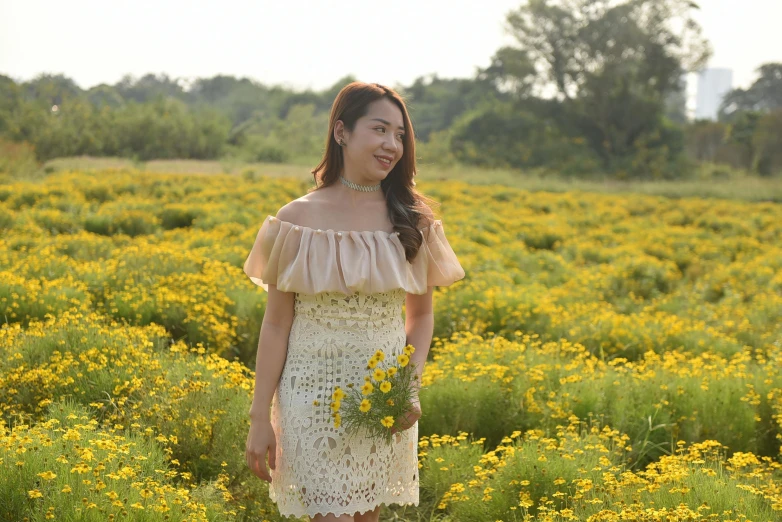 young woman in dress standing in field of flowers