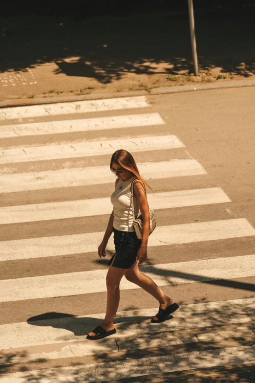 woman walking across the street on a cross walk