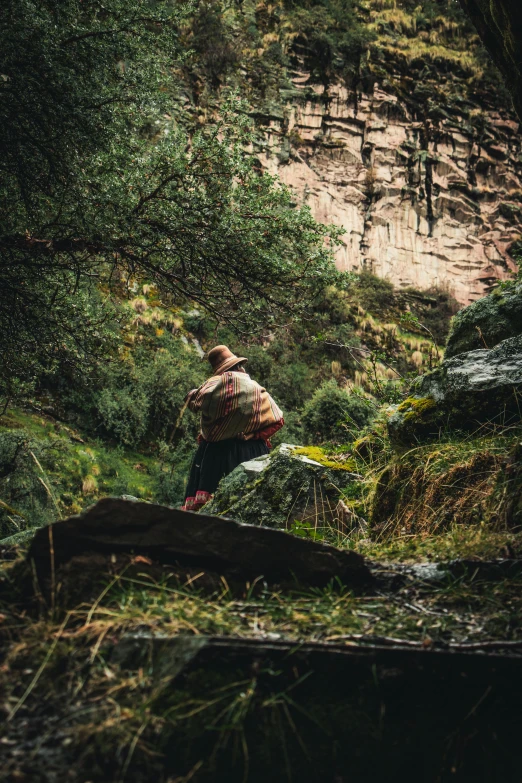 a person in an orange jacket is picking leaves