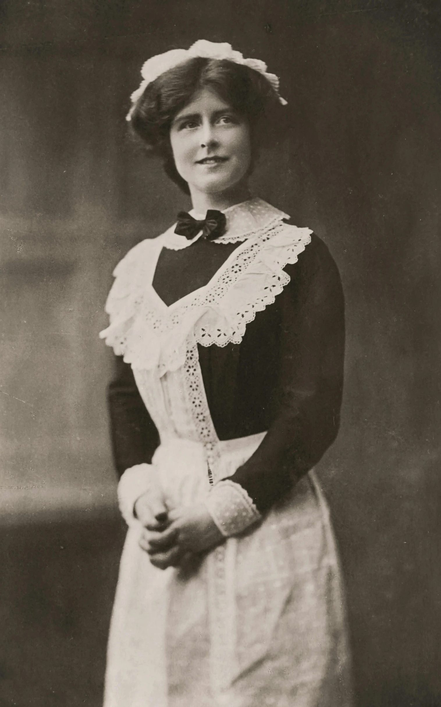 a woman wearing an apron with lace around the collar