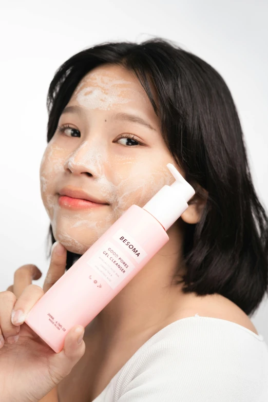 young asian woman with cosmetic mask and body lotion in a pose