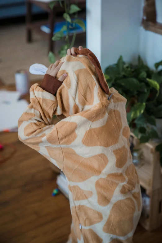 there is a giraffe blanket covering someone's head