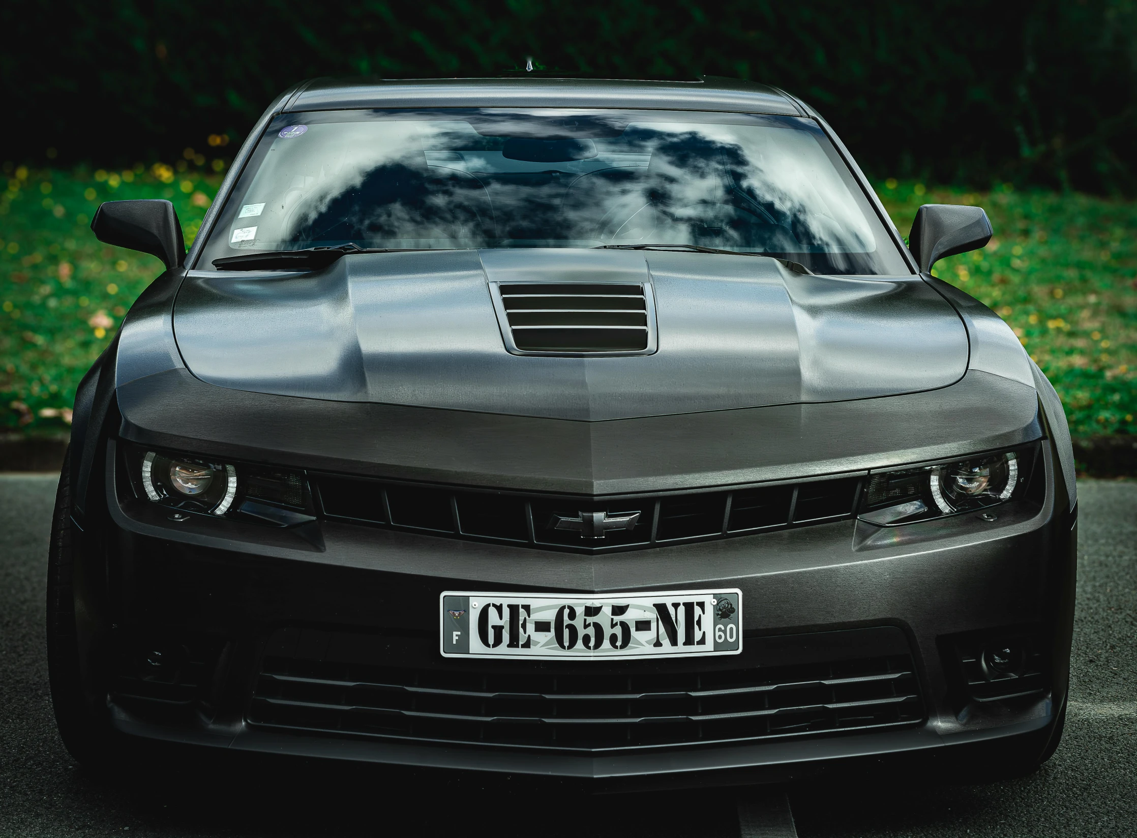 black camaro sports car sitting in a parking lot