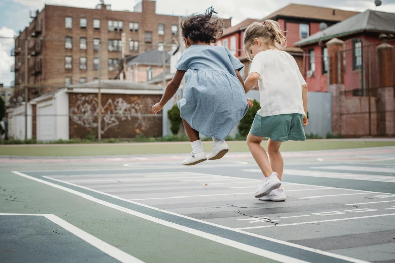 two s jumping up on a sidewalk