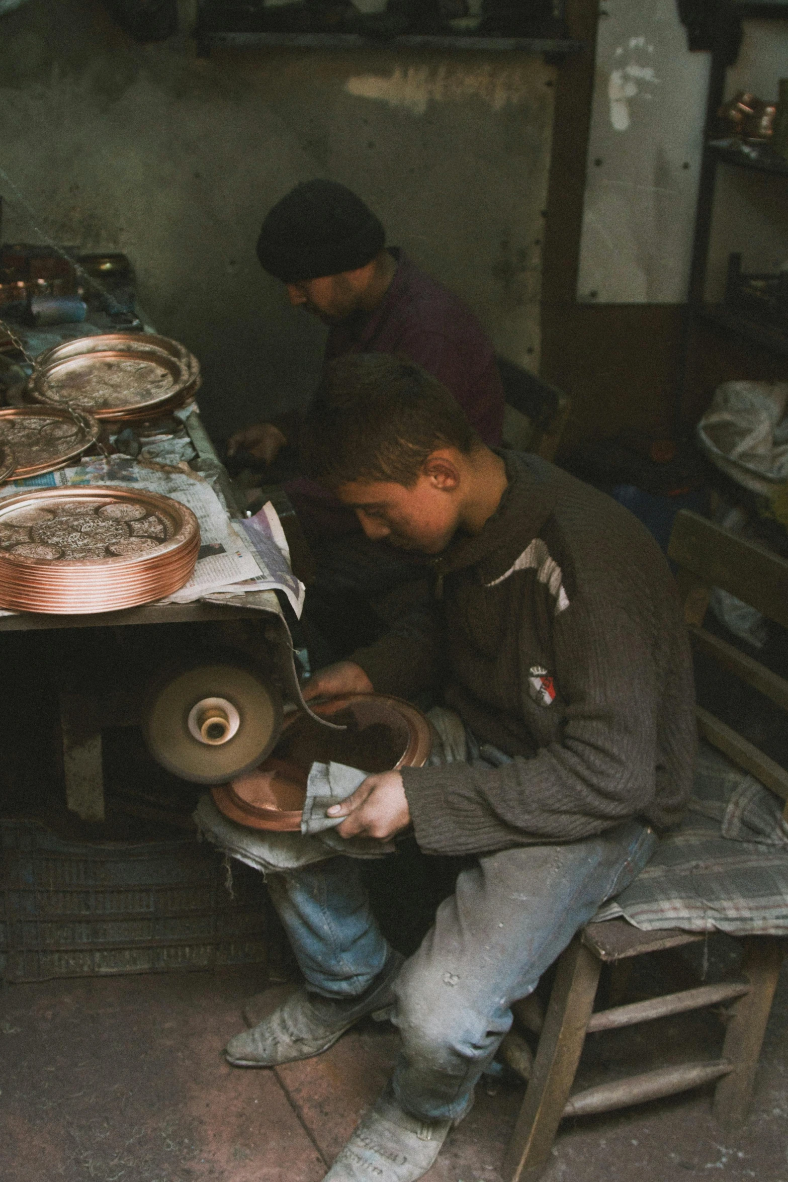 two men work on crafts in front of an open fire place