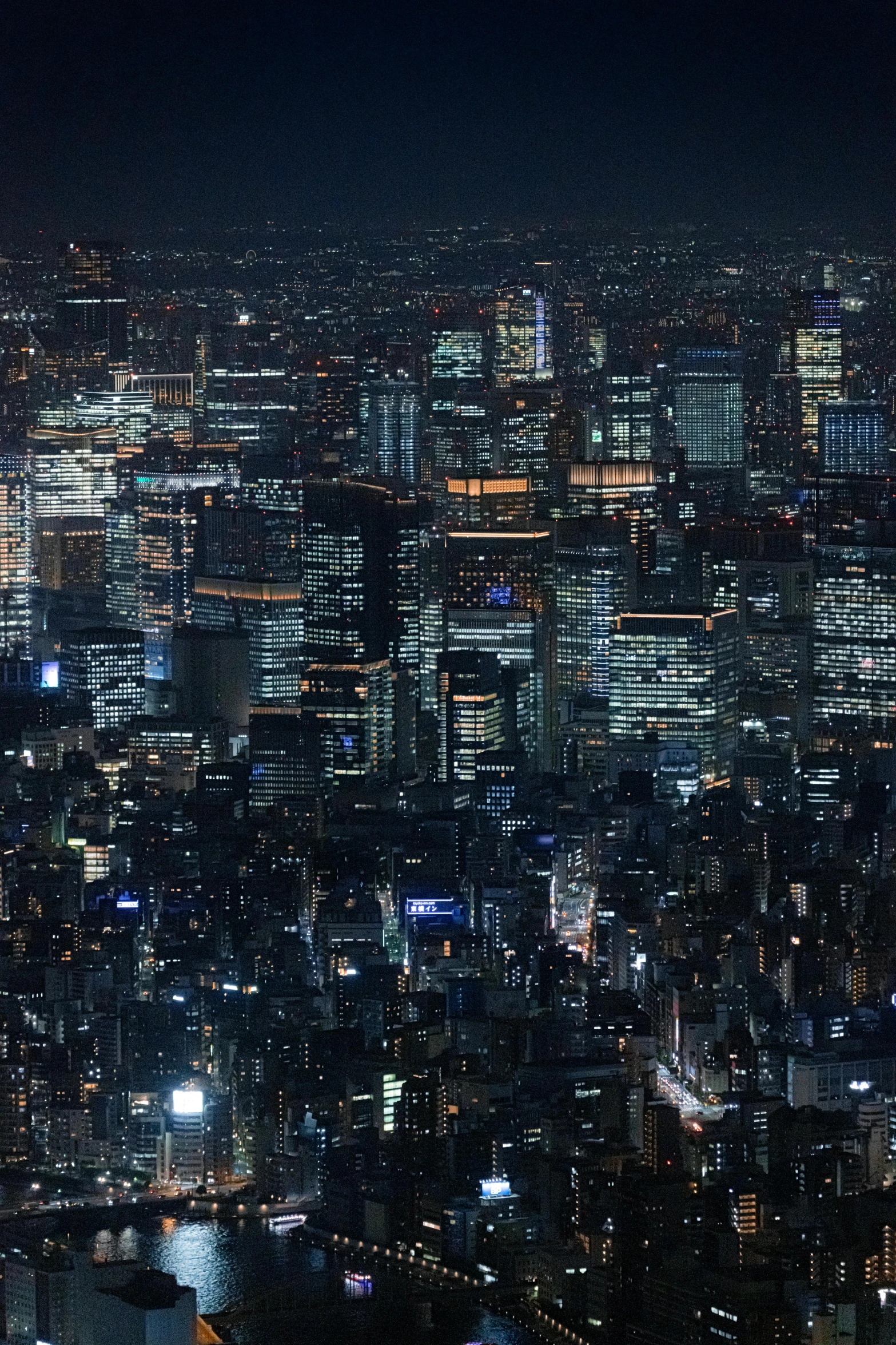 an aerial view of a city at night with the bright lights of skyscrs