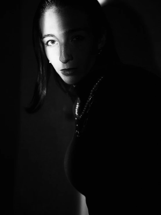 a woman is standing with a dark background