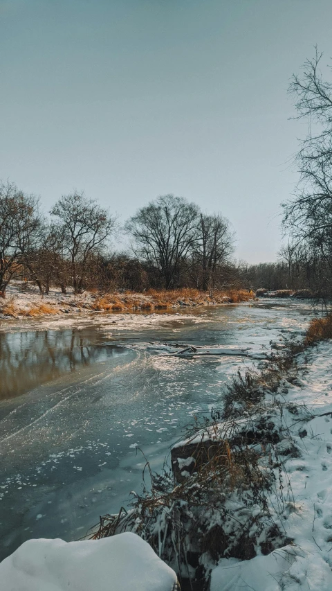 frozen lake by the road with a bridge in the background