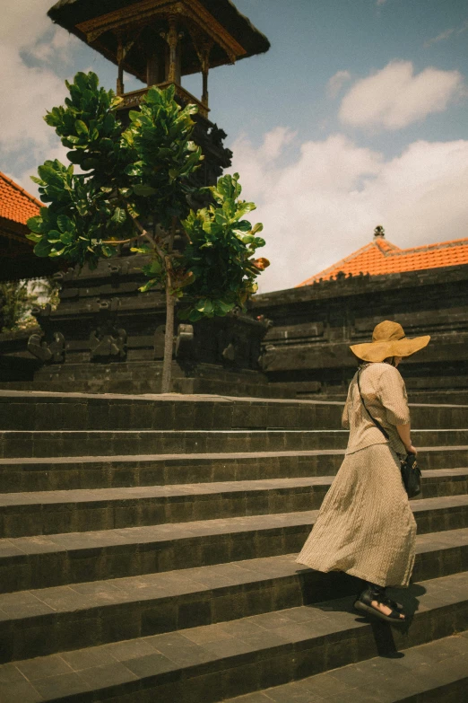 a woman walking down stairs carrying a basket