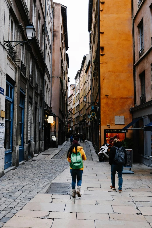 two people walking down the alleys in an old city